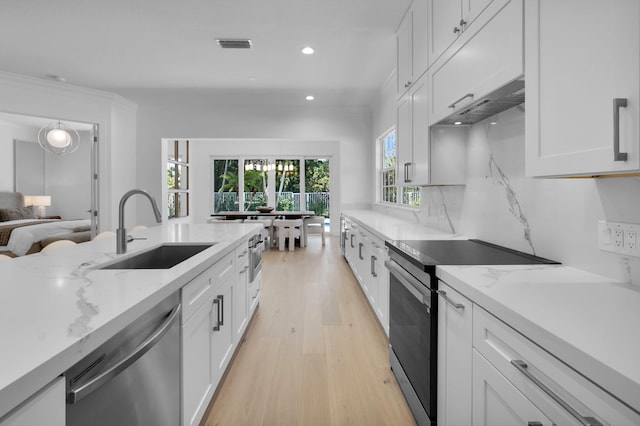 4689 Hammock Cir, Delray Beach, FL 33445 - kitchen with stainless steel appliances, a sink, custom range hood, light wood-type flooring, and white cabinetry