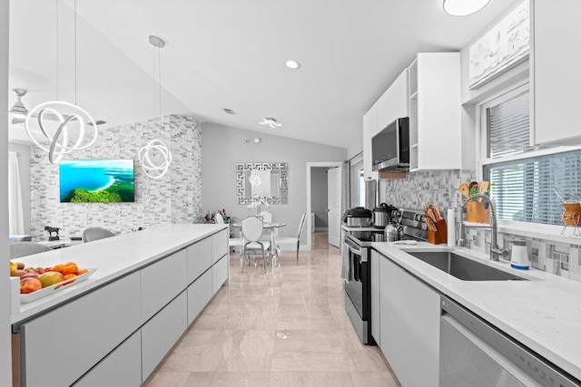2471 SE Leithgow St, Port Saint Lucie, FL 34952 - kitchen featuring stainless steel appliances, lofted ceiling, a sink, white cabinets, and light marble finish floors