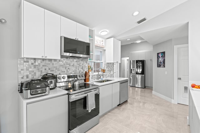 2471 SE Leithgow St, Port Saint Lucie, FL 34952 - kitchen featuring appliances with stainless steel finishes, a sink, tasteful backsplash, light marble finish floors, and light countertops