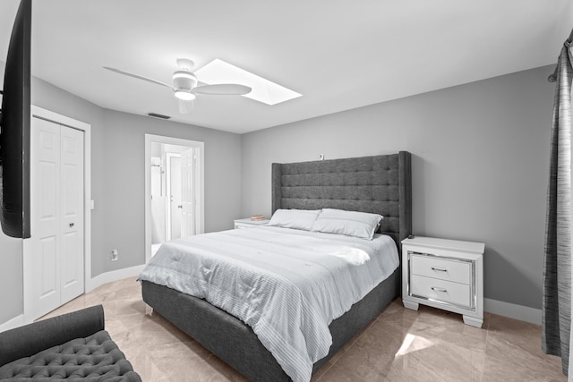 2471 SE Leithgow St, Port Saint Lucie, FL 34952 - bedroom featuring a skylight, ceiling fan, light marble finish floors, and baseboards