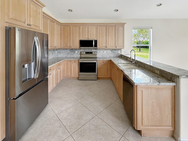 7725 Royale River Ln, Lake Worth, FL 33467 - kitchen featuring appliances with stainless steel finishes, light brown cabinets, a peninsula, a sink, and decorative backsplash