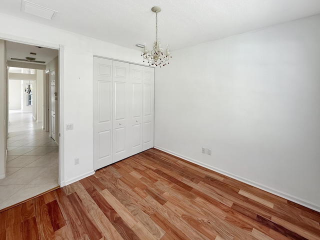 7725 Royale River Ln, Lake Worth, FL 33467 - unfurnished bedroom featuring a chandelier, a closet, baseboards, and light wood-style flooring
