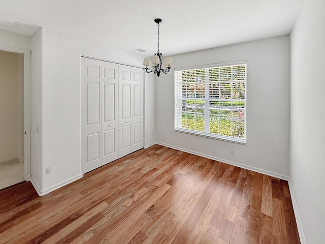 7725 Royale River Ln, Lake Worth, FL 33467 - unfurnished dining area with a chandelier, light wood finished floors, and baseboards