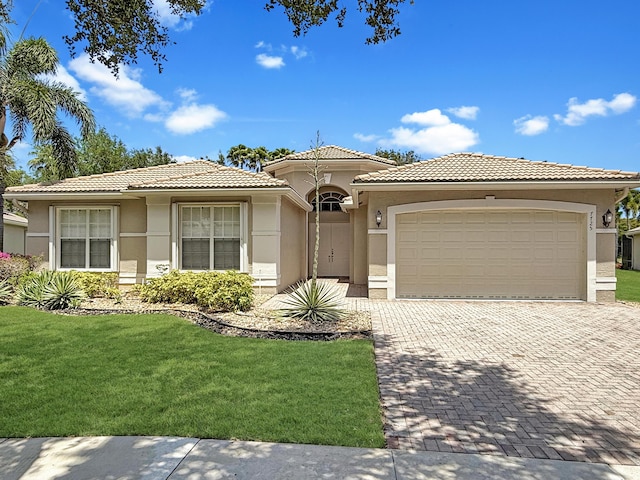 7725 Royale River Ln, Lake Worth, FL 33467 - view of front of house with decorative driveway, stucco siding, a front lawn, an attached garage, and a tile roof