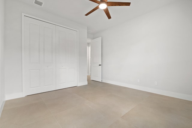13590 82nd St N, Loxahatchee, FL 33470 - unfurnished bedroom with a closet, light tile patterned flooring, a ceiling fan, and baseboards