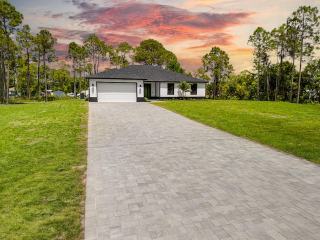 13590 82nd St N, Loxahatchee, FL 33470 - view of front of property featuring decorative driveway, an attached garage, and a front lawn