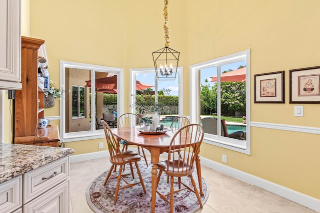 5986 Vista Linda Ln, Boca Raton, FL 33433 - dining area with a chandelier, a towering ceiling, light tile patterned floors, and baseboards