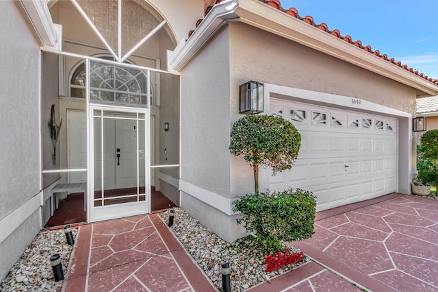 6690 Remington Pl, Lake Worth, FL 33463 - property entrance featuring stucco siding, an attached garage, and a tile roof