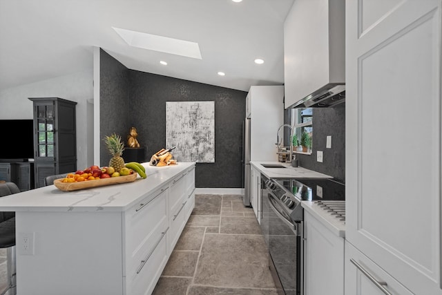 14244 Horseshoe Trce, Wellington, FL 33414 - kitchen with electric stove, wall chimney exhaust hood, lofted ceiling, a skylight, and recessed lighting