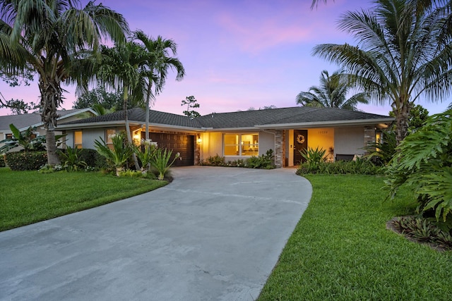 14244 Horseshoe Trce, Wellington, FL 33414 - ranch-style home with an attached garage, driveway, stucco siding, and a front lawn