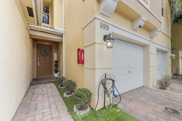 899 Pipers Cay Dr, West Palm Beach, FL 33415 - property entrance with stucco siding and a garage