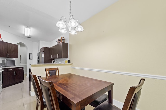 899 Pipers Cay Dr, West Palm Beach, FL 33415 - dining area with arched walkways, light tile patterned flooring, and a chandelier