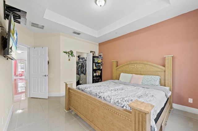 899 Pipers Cay Dr, West Palm Beach, FL 33415 - bedroom with baseboards, a tray ceiling, light tile patterned floors, and a spacious closet