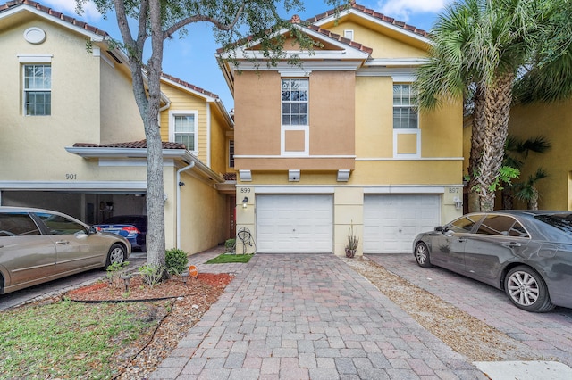 899 Pipers Cay Dr, West Palm Beach, FL 33415 - view of property featuring a garage, driveway, stucco siding, and a tile roof