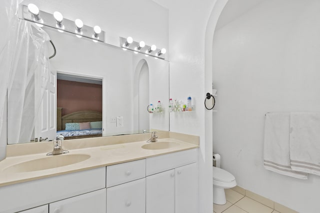 899 Pipers Cay Dr, West Palm Beach, FL 33415 - ensuite bathroom with tile patterned floors, double vanity, and toilet