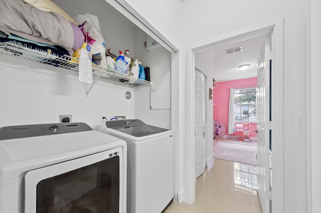 899 Pipers Cay Dr, West Palm Beach, FL 33415 - laundry area with washing machine and dryer and light tile patterned flooring