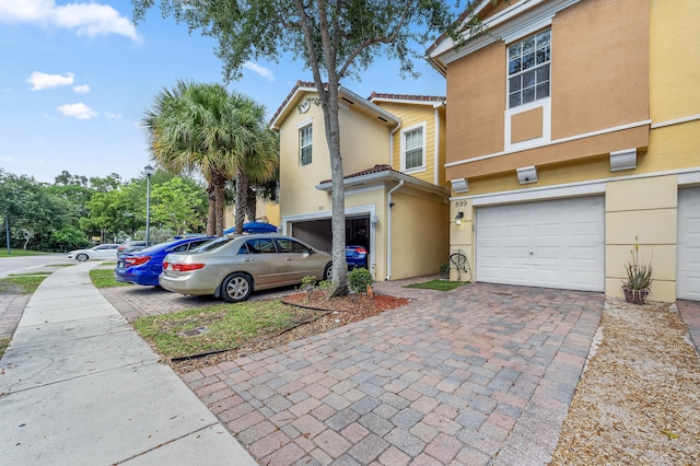 899 Pipers Cay Dr, West Palm Beach, FL 33415 - view of front of home with a garage, decorative driveway, and stucco siding