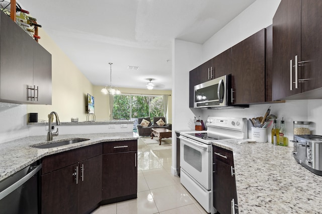 899 Pipers Cay Dr, West Palm Beach, FL 33415 - kitchen with appliances with stainless steel finishes, a sink, light stone countertops, and dark brown cabinets
