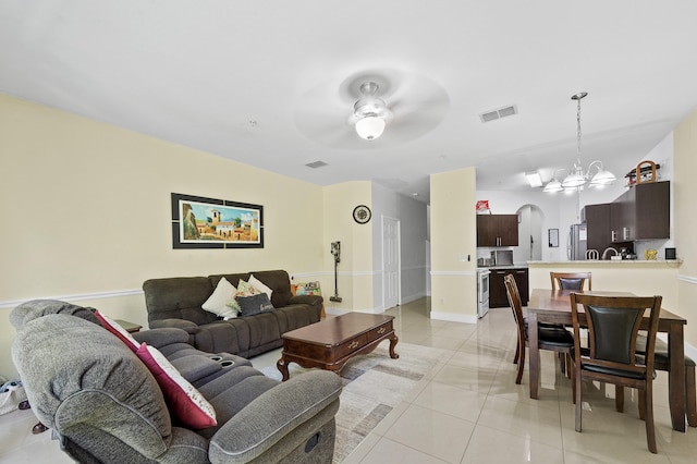 899 Pipers Cay Dr, West Palm Beach, FL 33415 - living area featuring a chandelier, light tile patterned flooring, arched walkways, a ceiling fan, and baseboards