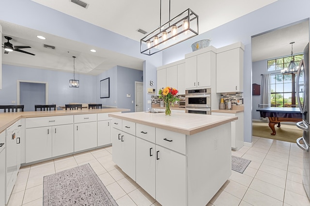 756 SW Pelican Cv, Port Saint Lucie, FL 34986 - kitchen with a chandelier, light tile patterned floors, a kitchen island, and recessed lighting
