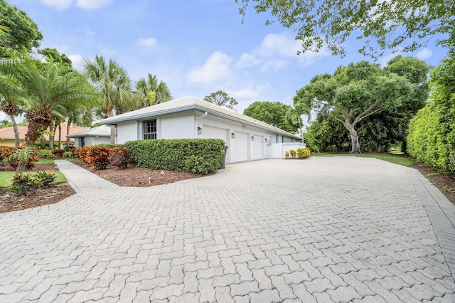 756 SW Pelican Cv, Port Saint Lucie, FL 34986 - view of side of home with decorative driveway, stucco siding, and an attached garage