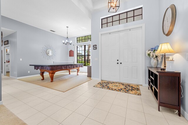 756 SW Pelican Cv, Port Saint Lucie, FL 34986 - foyer entrance featuring a chandelier, baseboards, light tile patterned flooring, and a high ceiling