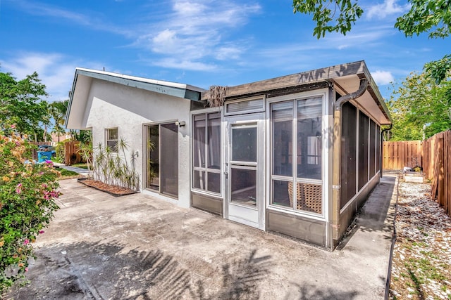 82 Baytree Cir, Boynton Beach, FL 33436 - back of house featuring a sunroom, a patio, a fenced backyard, and stucco siding