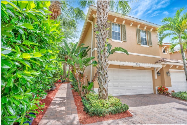 5030 Dulce Ct, Palm Beach Gardens, FL 33418 - view of front of property with stucco siding, an attached garage, decorative driveway, and a tile roof