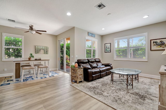 5030 Dulce Ct, Palm Beach Gardens, FL 33418 - living room featuring healthy amount of natural light, wood finished floors, baseboards, recessed lighting, and a textured ceiling
