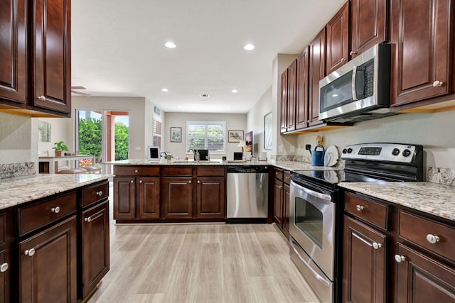 5030 Dulce Ct, Palm Beach Gardens, FL 33418 - kitchen featuring appliances with stainless steel finishes, light wood-type flooring, a peninsula, light stone counters, and dark brown cabinetry