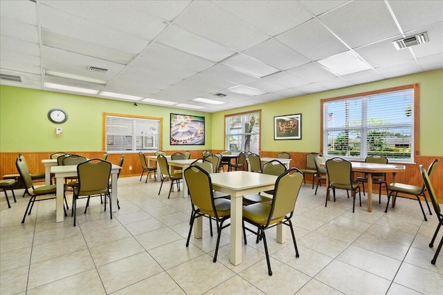 2597 Emory Dr W Unit G, West Palm Beach, FL 33415 - dining area featuring a wainscoted wall, wood walls, a drop ceiling, and light tile patterned floors