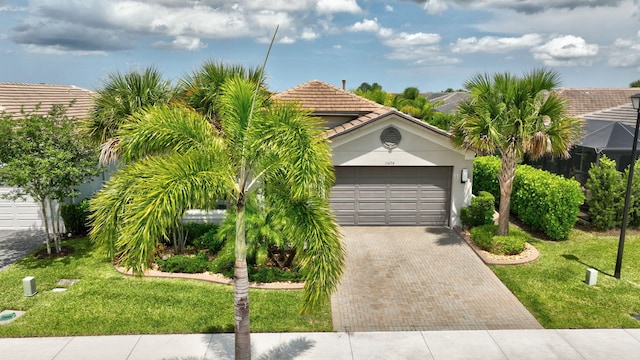 11454 SW Hawkins Ter, Port Saint Lucie, FL 34987 - view of front of property with decorative driveway, a front yard, an attached garage, a tiled roof, and stucco siding