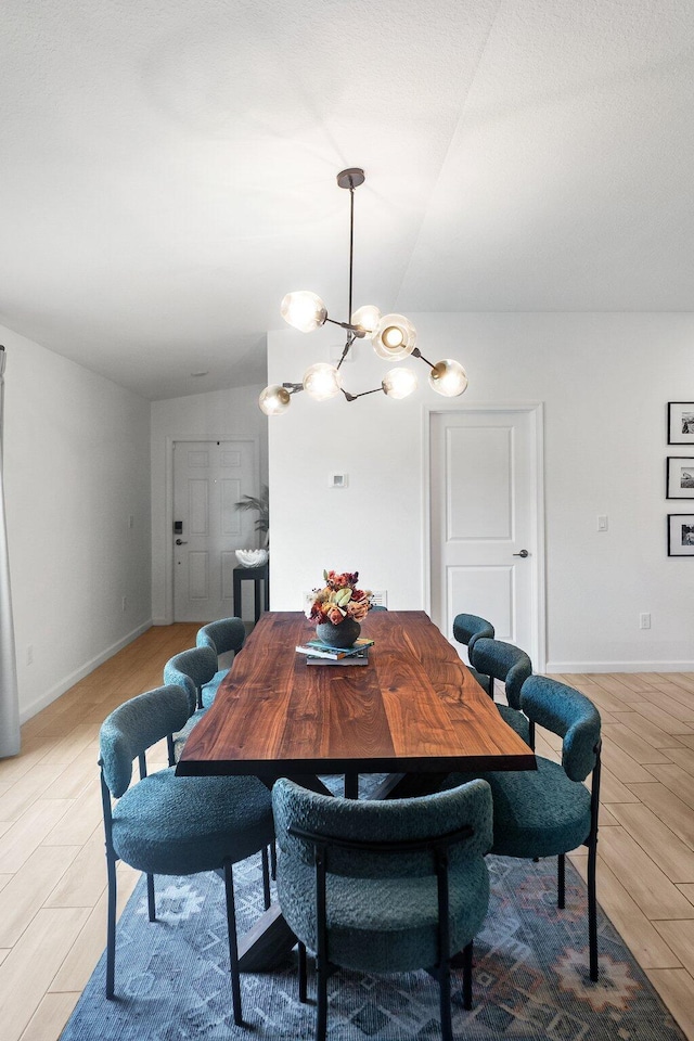 956 Bent Creek Dr, Fort Pierce, FL 34947 - dining area featuring a chandelier, baseboards, light wood finished floors, and lofted ceiling