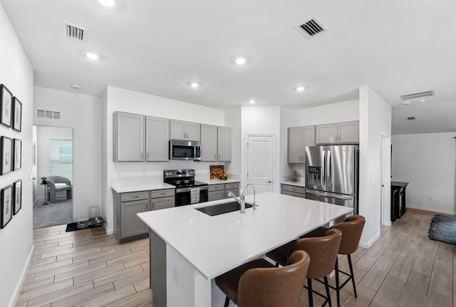 956 Bent Creek Dr, Fort Pierce, FL 34947 - kitchen with stainless steel appliances, gray cabinets, a sink, wood tiled floors, and recessed lighting