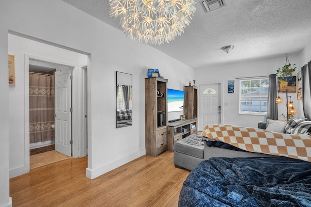 1005 SW 15th Ter, Fort Lauderdale, FL 33312 - bedroom featuring light wood finished floors, a textured ceiling, a chandelier, and baseboards