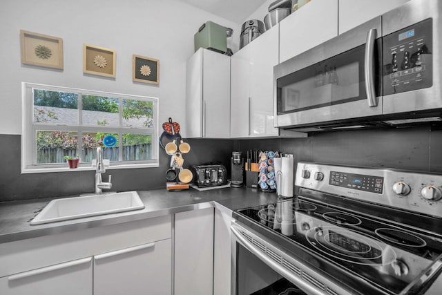 1005 SW 15th Ter, Fort Lauderdale, FL 33312 - kitchen featuring appliances with stainless steel finishes, white cabinetry, and a sink