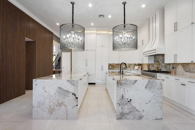 17725 Circle Pond Ct, Boca Raton, FL 33496 - kitchen with a large island with sink, a chandelier, tasteful backsplash, crown molding, and recessed lighting