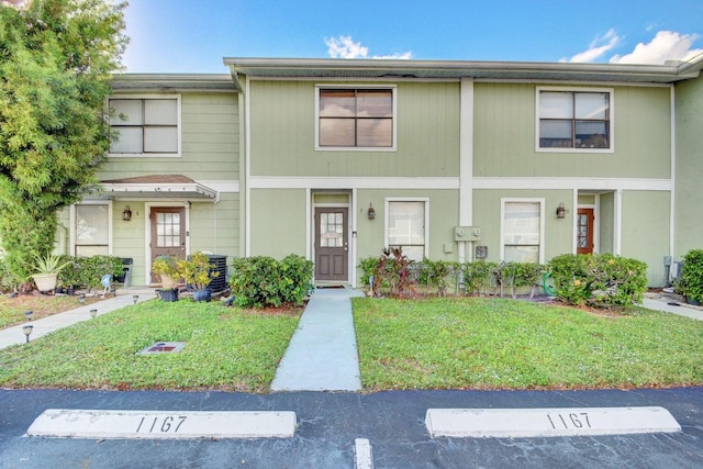 799 Hill Dr Unit F, West Palm Beach, FL 33415 - view of property with uncovered parking and a front lawn