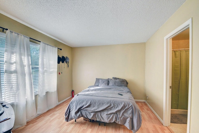 799 Hill Dr Unit F, West Palm Beach, FL 33415 - bedroom with light wood finished floors, a textured ceiling, and baseboards