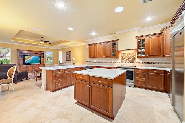 18974 SE Jupiter River Dr, Jupiter, FL 33458 - kitchen with stainless steel appliances, a peninsula, open floor plan, decorative backsplash, and crown molding