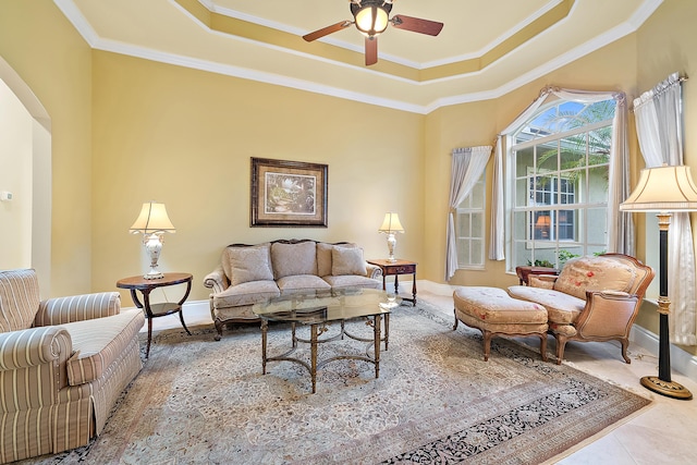 18974 SE Jupiter River Dr, Jupiter, FL 33458 - living area featuring a tray ceiling, baseboards, arched walkways, ornamental molding, and a ceiling fan