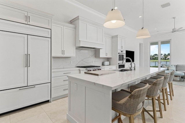 206 Via Emilia, Palm Beach Gardens, FL 33418 - kitchen featuring crown molding, tasteful backsplash, light tile patterned floors, a sink, and light stone countertops