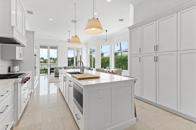 206 Via Emilia, Palm Beach Gardens, FL 33418 - kitchen featuring ornamental molding, a sink, stainless steel appliances, a kitchen island with sink, and plenty of natural light