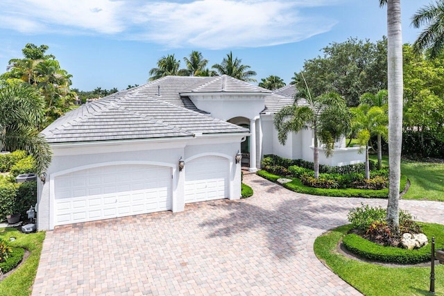 206 Via Emilia, Palm Beach Gardens, FL 33418 - view of front of home featuring decorative driveway, stucco siding, a garage, and a tiled roof