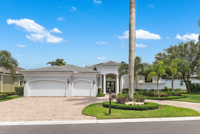 206 Via Emilia, Palm Beach Gardens, FL 33418 - mediterranean / spanish-style home featuring french doors, decorative driveway, an attached garage, stucco siding, and a tiled roof