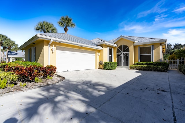 2925 SW Brighton Way, Palm City, FL 34990 - view of front of home with a standing seam roof, stucco siding, metal roof, an attached garage, and concrete driveway