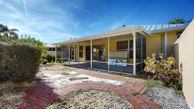 2925 SW Brighton Way, Palm City, FL 34990 - back of house featuring a sunroom, stucco siding, a standing seam roof, and metal roof