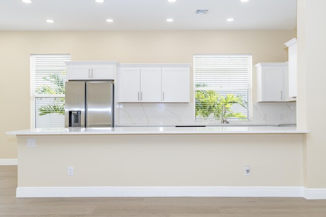 2925 SW Brighton Way, Palm City, FL 34990 - kitchen featuring stainless steel fridge with ice dispenser, recessed lighting, light countertops, white cabinets, and light wood-type flooring