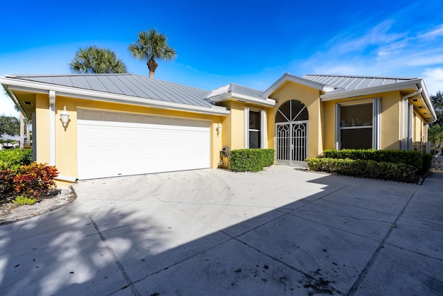 2925 SW Brighton Way, Palm City, FL 34990 - single story home with a standing seam roof, stucco siding, an attached garage, concrete driveway, and metal roof