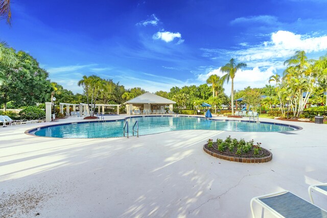 2925 SW Brighton Way, Palm City, FL 34990 - community pool featuring a patio and view of scattered trees